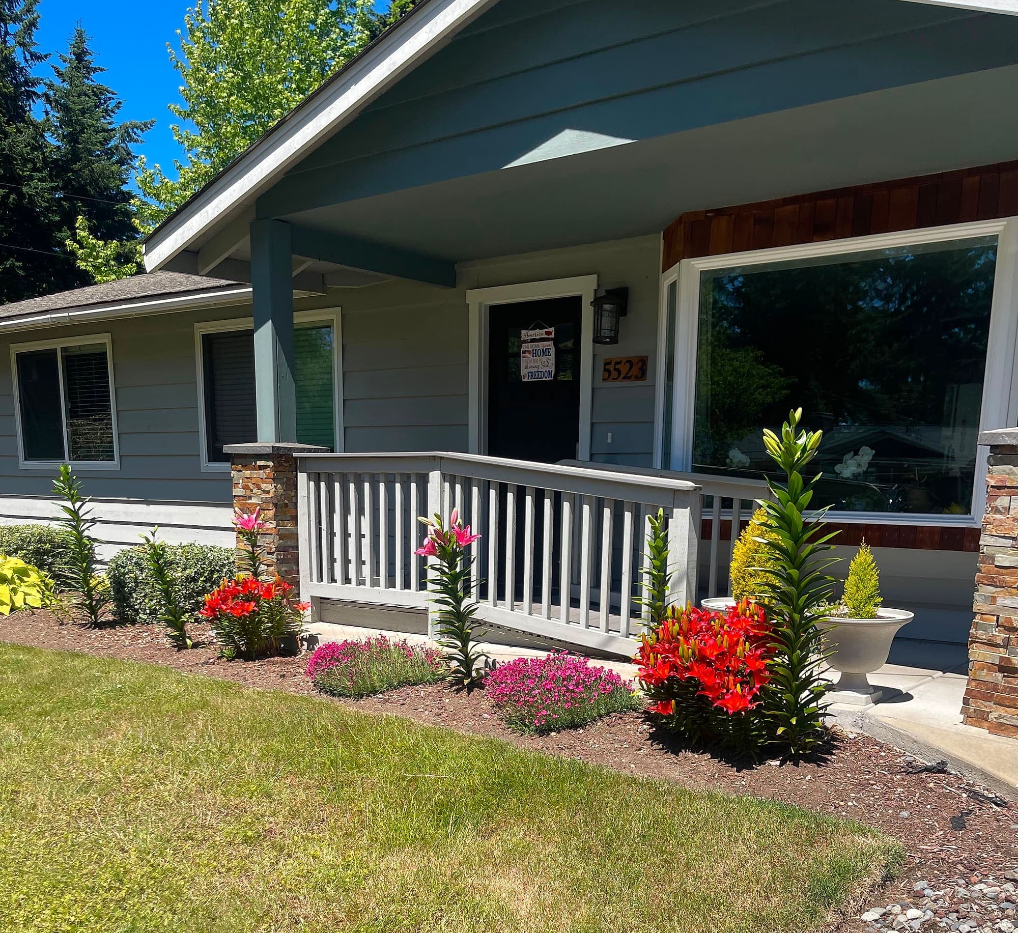 The front of Abbey Road Care Homes at 5523 141st Street SW in Edmonds, Washington, with a step-free ramp and a garden of red lilies