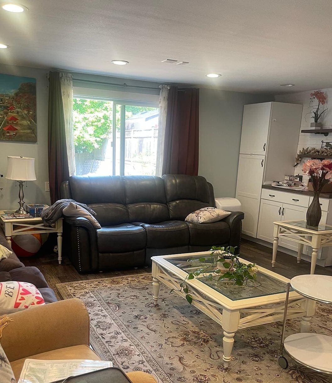A reclining sofa in the living room at Abbey Road Care Homes, facing the garden through a sliding door