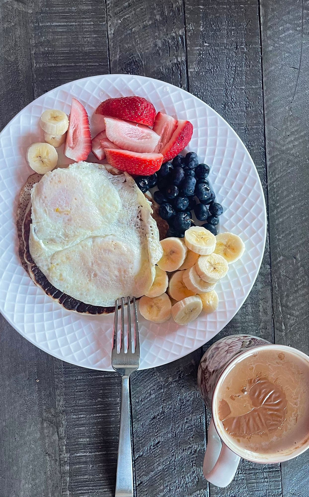 Pancakes with fried eggs, strawberries, blueberries and banana, served with coffee at Abbey Road Care Homes
